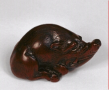 Masatomo wood netsuke - A very fine small wood netsuke of a boar lying looking up, and slightly to the right, the legs folded beneath, the hair work is nicely worn.  The cord attachment under the right hind leg.  Japan, 19th century.  Signed: Masatomo, Nagoya.  Provenance: Sotheby's.  Published: Item 241 'In Search of Netsuke and Inro' by George A. Cohen.  Illustrated in 'The Wonderful World of Netsuke' by Raymond Bushell. 